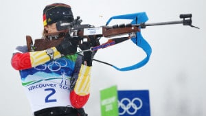 biathlon athlete holding a rifle ready to shoot Olympics logo and white snow background