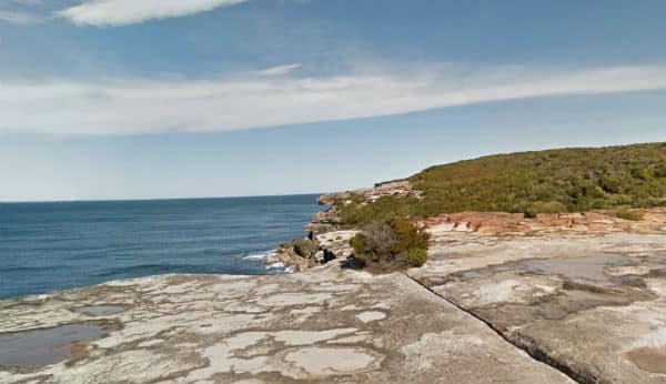 Coast walk in the Royal National Park., showing the sea, a cliff and heath shrubs