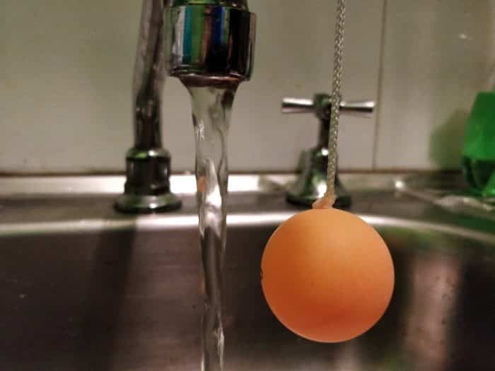 Ping pong ball on a string experiment - ball hanging away from water stream at the start