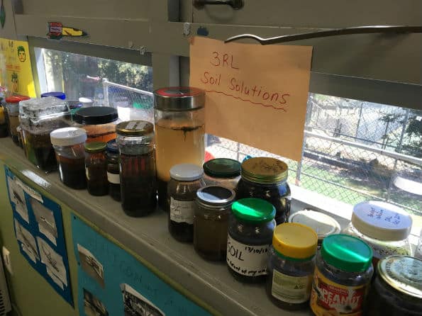 Soil sedimentation experiment jars along a windowsill 