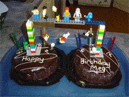 Two chocolate cakes joined together with a Lego brudge and Lego minfigures