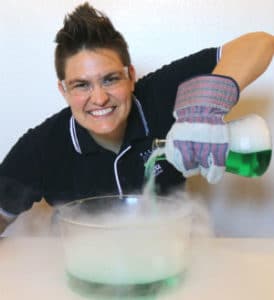 Jeanette pouring in fogging dry ice and green liquid into a bowl