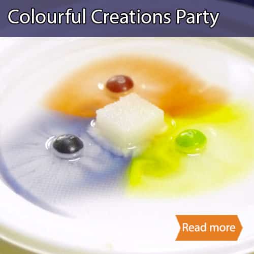 Coloured skittles and sugar in water on a plate